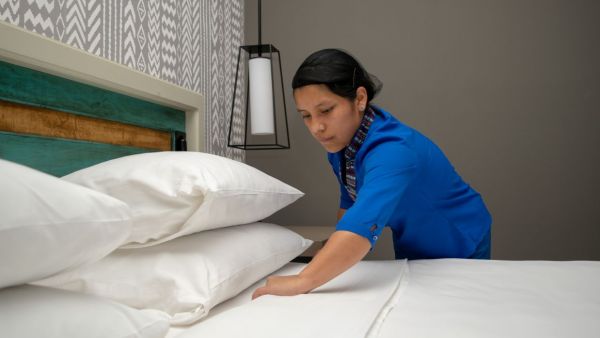 Young hotel housekeeper training how to make a bed. She is a participant of our youth employment programme in Latin America.