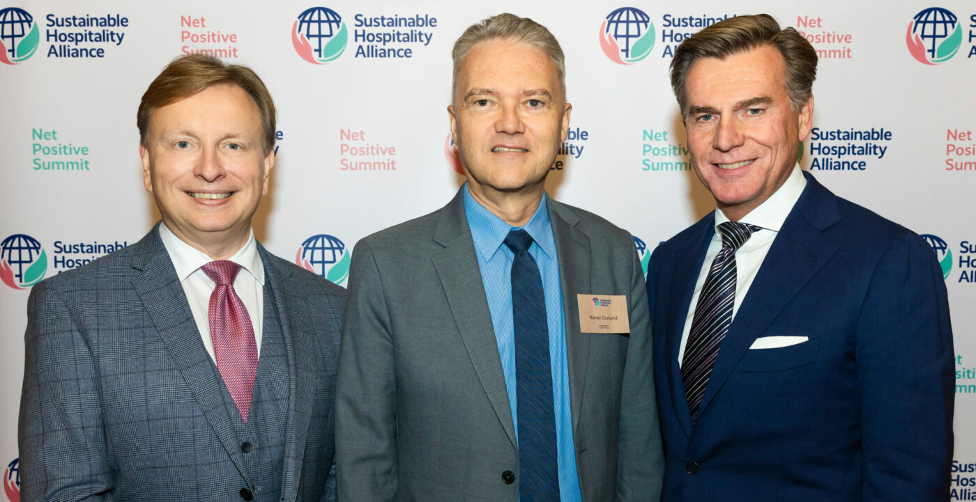 Image shows Sustainable Hospitality Alliance CEO, Glenn Mandziuk, and Chairman, Wolfgang M. Neumann, with GSTC CEO, Randy Durband, at the Alliance's Net Positive Summit.