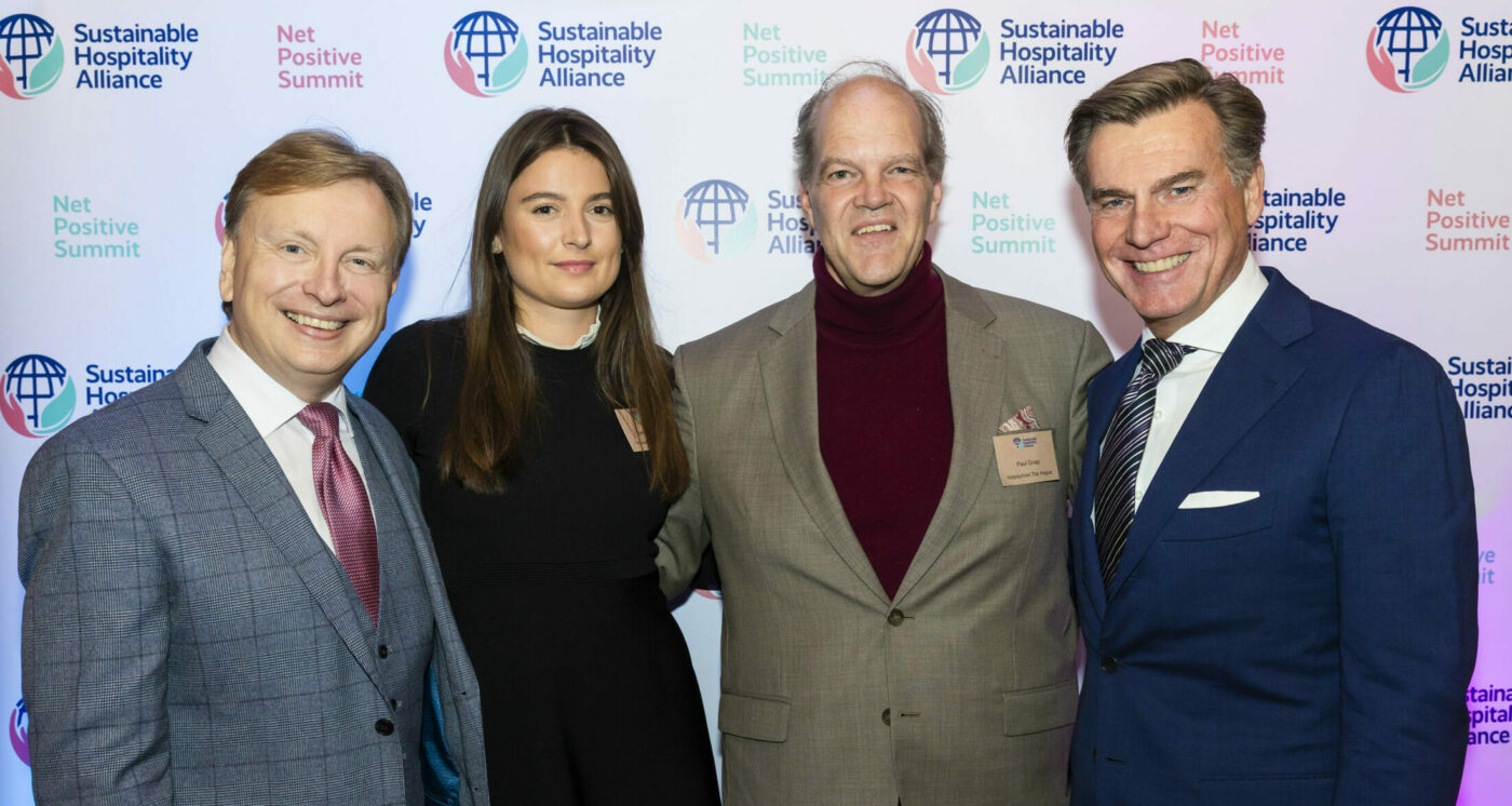 Photo shows Alliance CEO, Glenn Mandziuk, and Chair, Wolfgang M Neumann, posing for a photo with Stella Van Toor and Paul Griep, Directors of the Sustainable Hospitality Challenge, in front of a step and repeat banner at the Alliance's 2022 Autumn Summit.